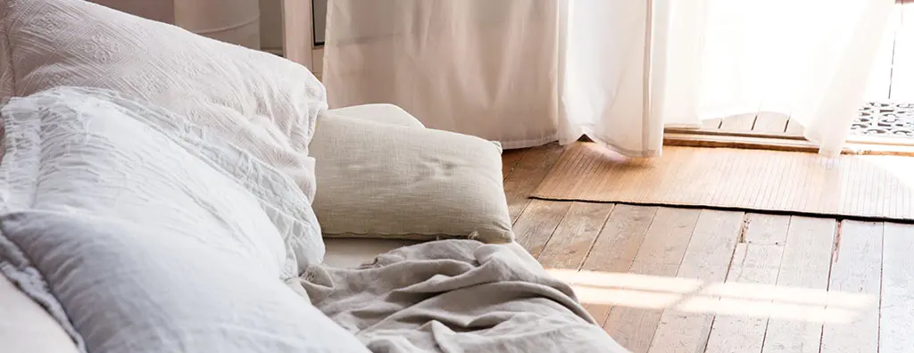 Pillows arranged on a wooden floor with the windows open