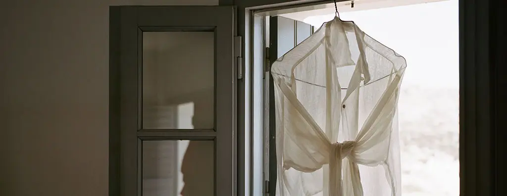 White shirt hanging in front of an open window