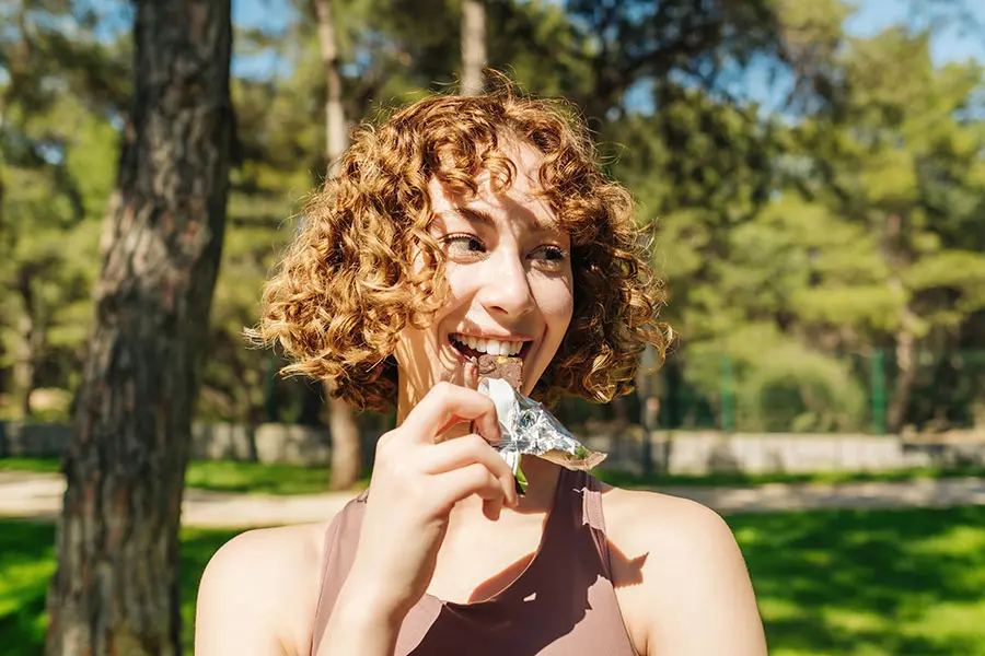 A woman eating a snack bar