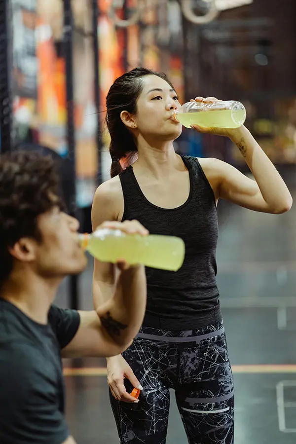 Two people drinking sports drinks after exercises