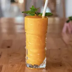 A glass of mango juice with a straw