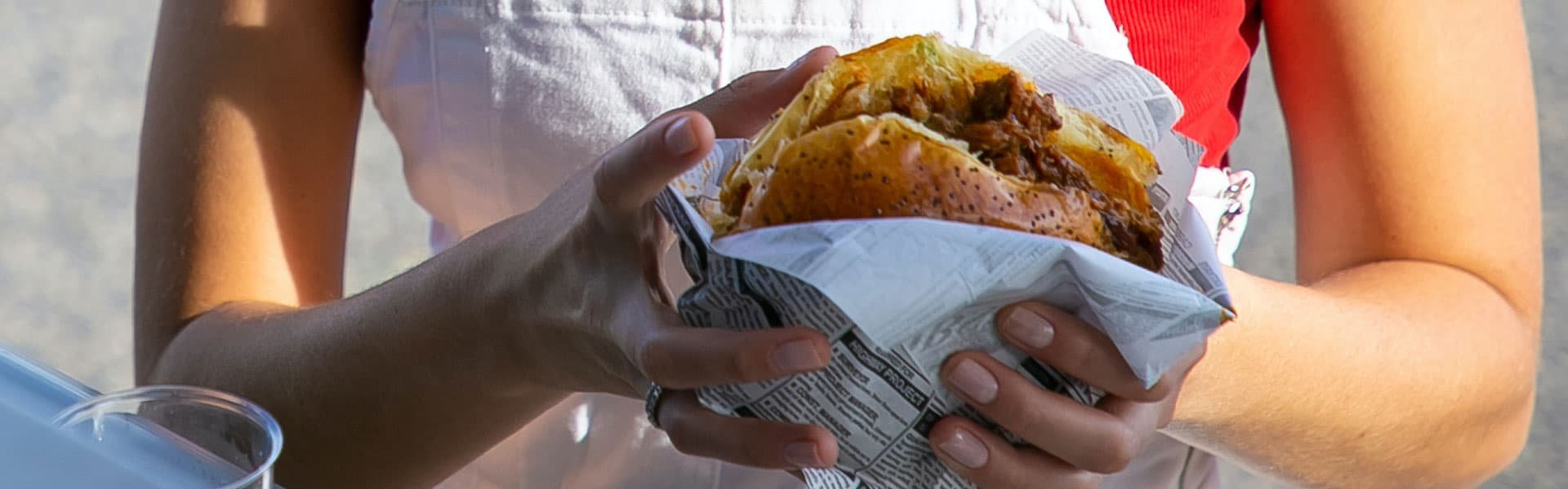 Lady holding bun with meat