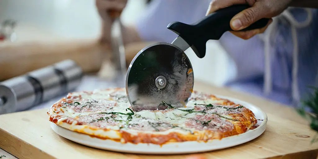 Finished cooked pizza being sliced