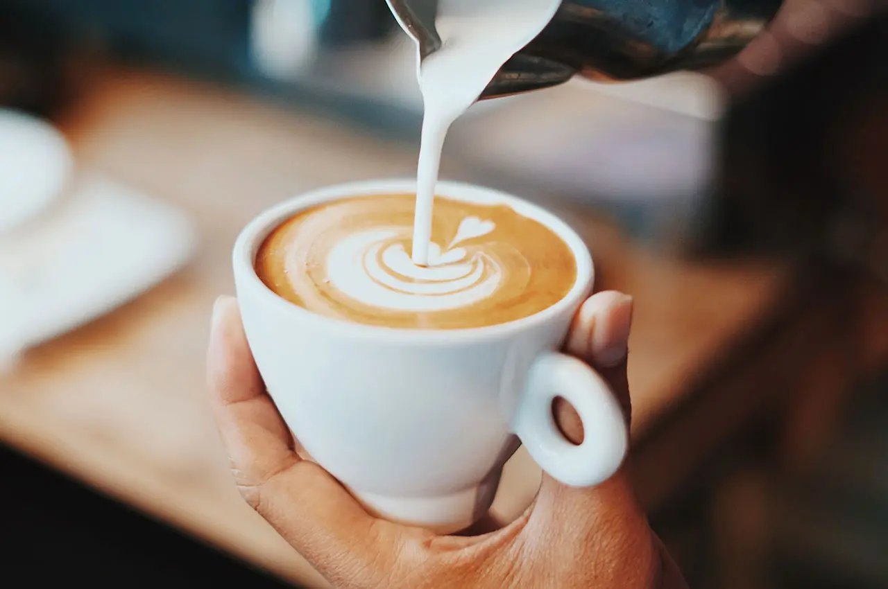 Pouring milk in coffee