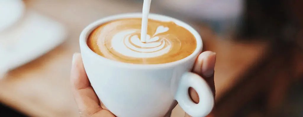 Pouring milk in coffee