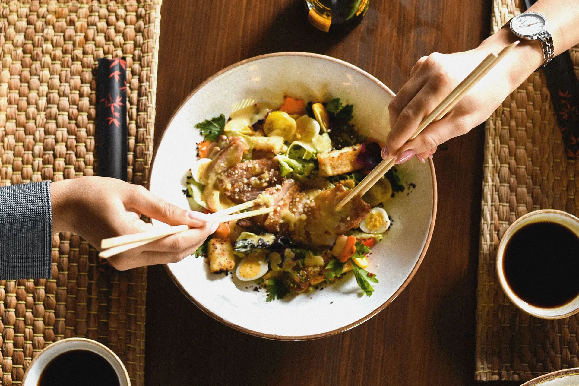 Sharing savoury dish with chopsticks