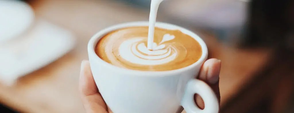 Pouring cream in coffee