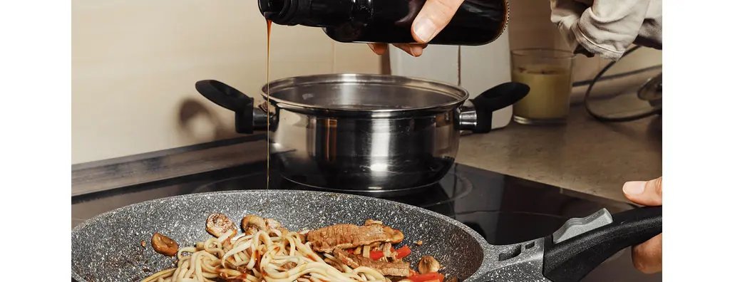 Pouring soy sauce on stir fried beef noodle