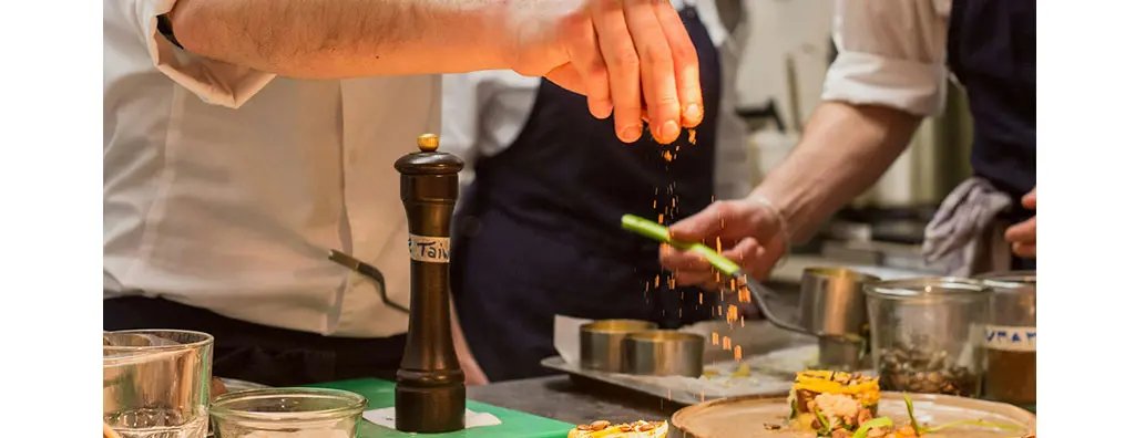 Chef seasoning a dish