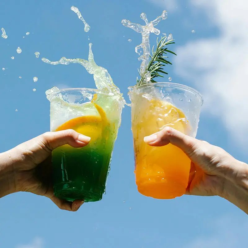 Two hands holding up soft drinks