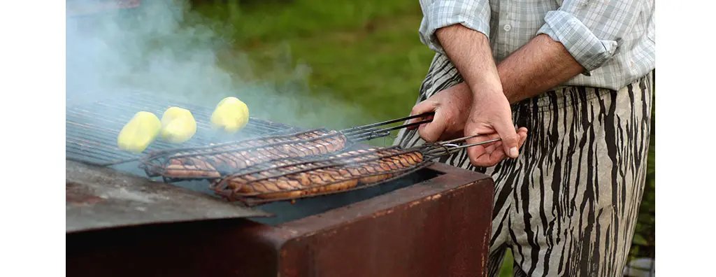 A person grilling meat on a grill
