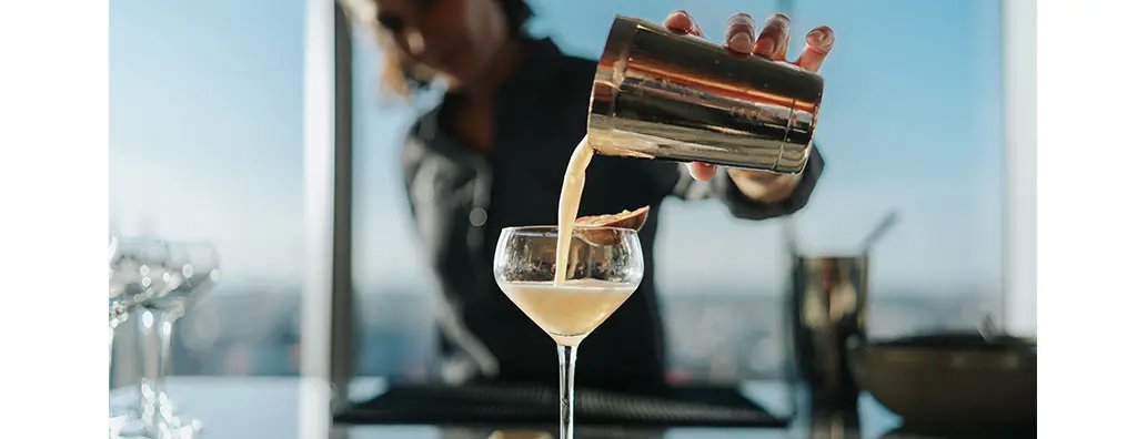 A person pouring a drink into a glass