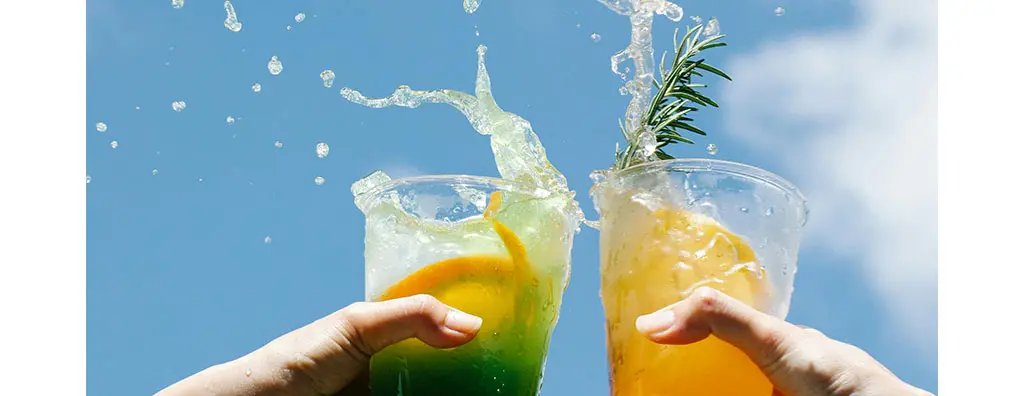 Two hands holding cups with drinks