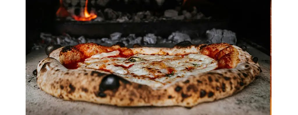 A pizza on a wood stove