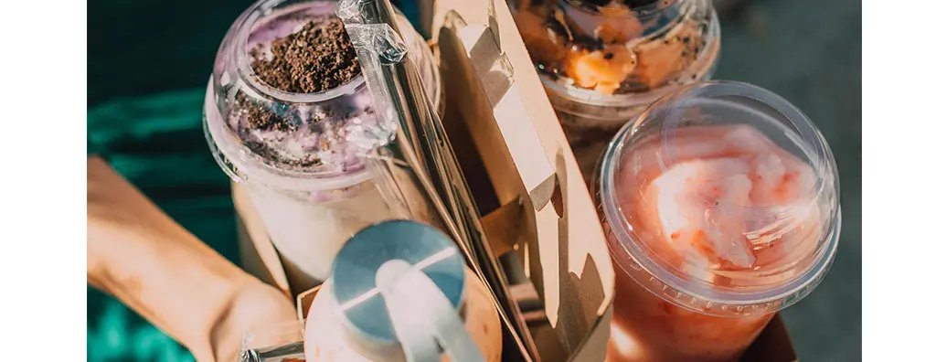 Four types of drinks in plastic cups in a paper tray