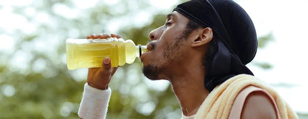Young man with beanie drinking an ice tea