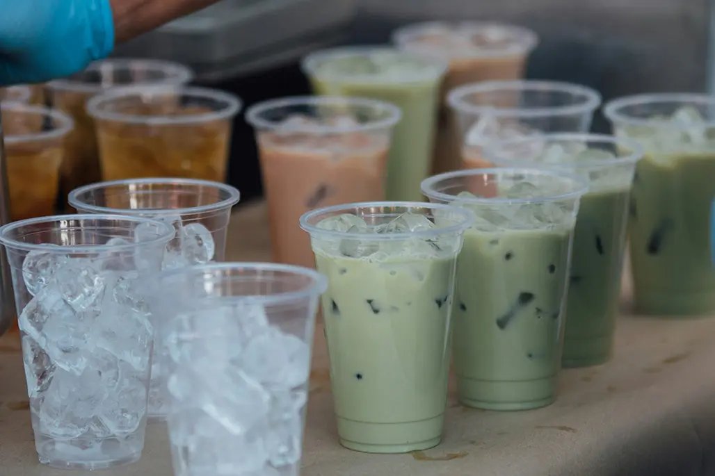 Varies coloured glasses with ice teas on a table