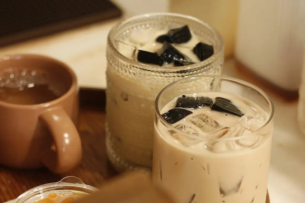 Two glasses with creamy ice tea with chocolate pieces on top