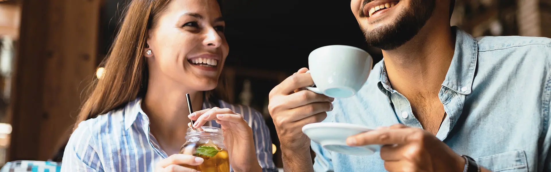 GenAI: A young couple sitting outside of a bar drinking hot and cold tea