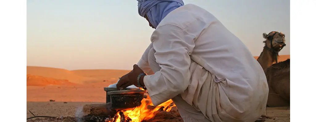Egyptian cooking with a pan on an open fire in the dessert