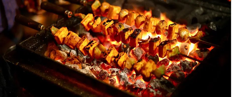 Skewers with meat and vegetables on a fire