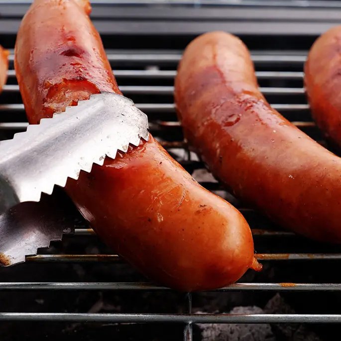 Sauces on a barbecue one holding with tongs