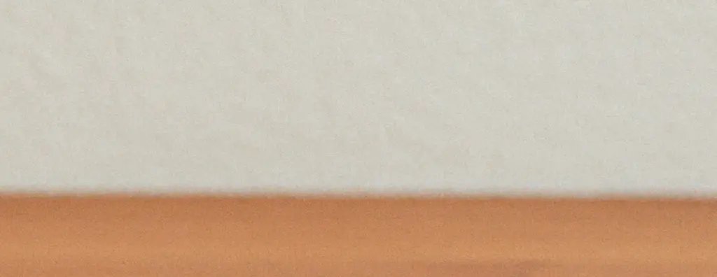 A cut orange and orange juice on a wooden serving tray on a wooden table