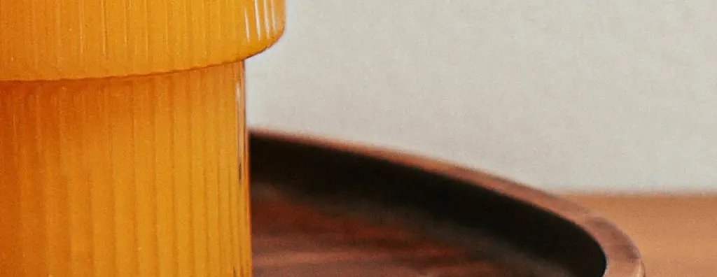 A cut orange and orange juice on a wooden serving tray on a wooden table