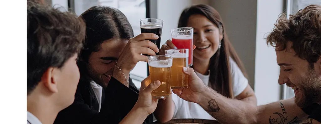 Four young people toasting with different varieties of beer
