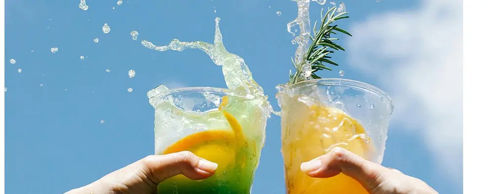 Toasting with beverages in the air making the liquid go over the drink cup