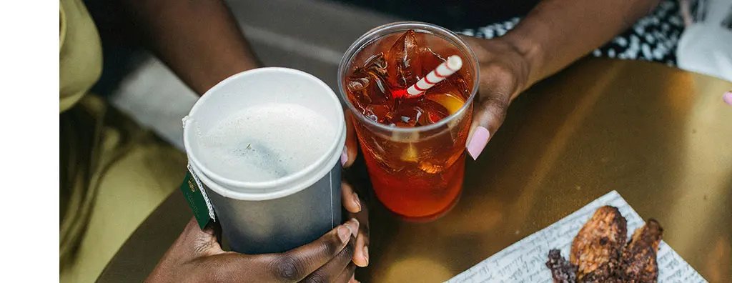 Two people holding a warm and ice tea