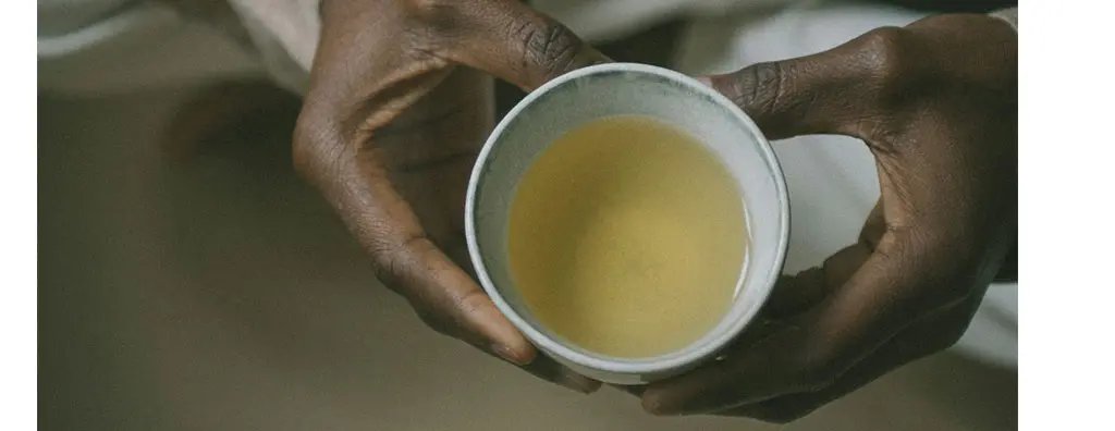Two hands holding a cup of tea
