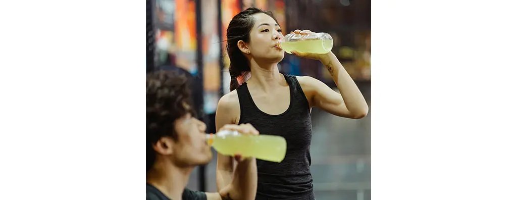 Two people drinking a sports drink after exercise