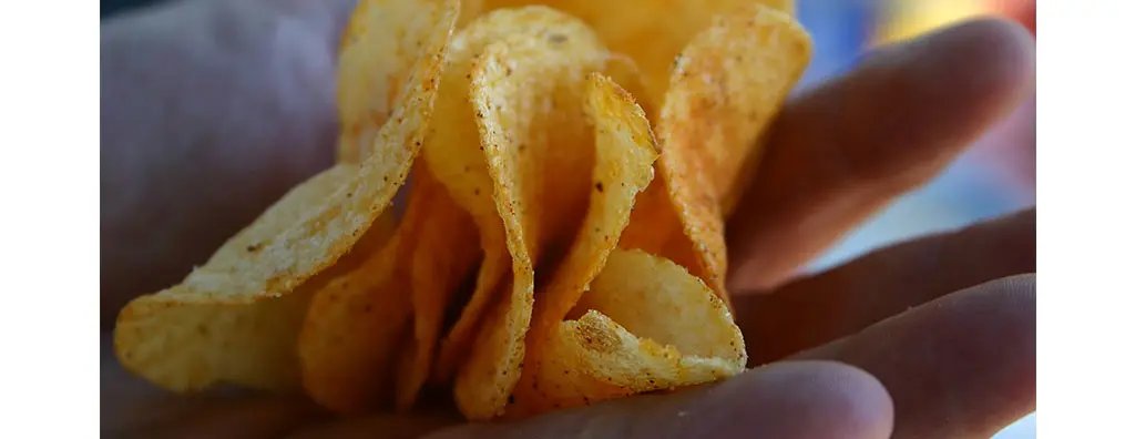 A hand filled with crisps