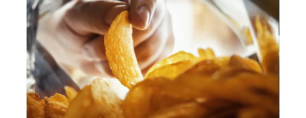A person taking a crisp