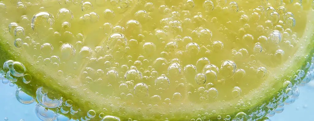 Close up of a slice of lime in a carbonate beverage