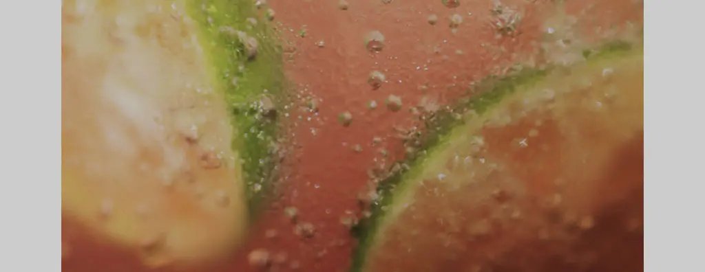 Close up of slices of lime in an orange beverage