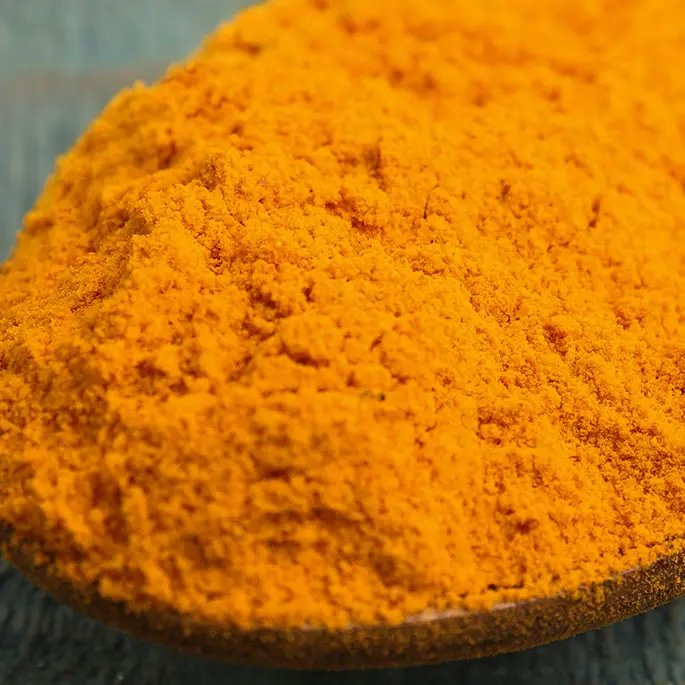 An ambery-coloured powder on a spoon representing beta-carotene